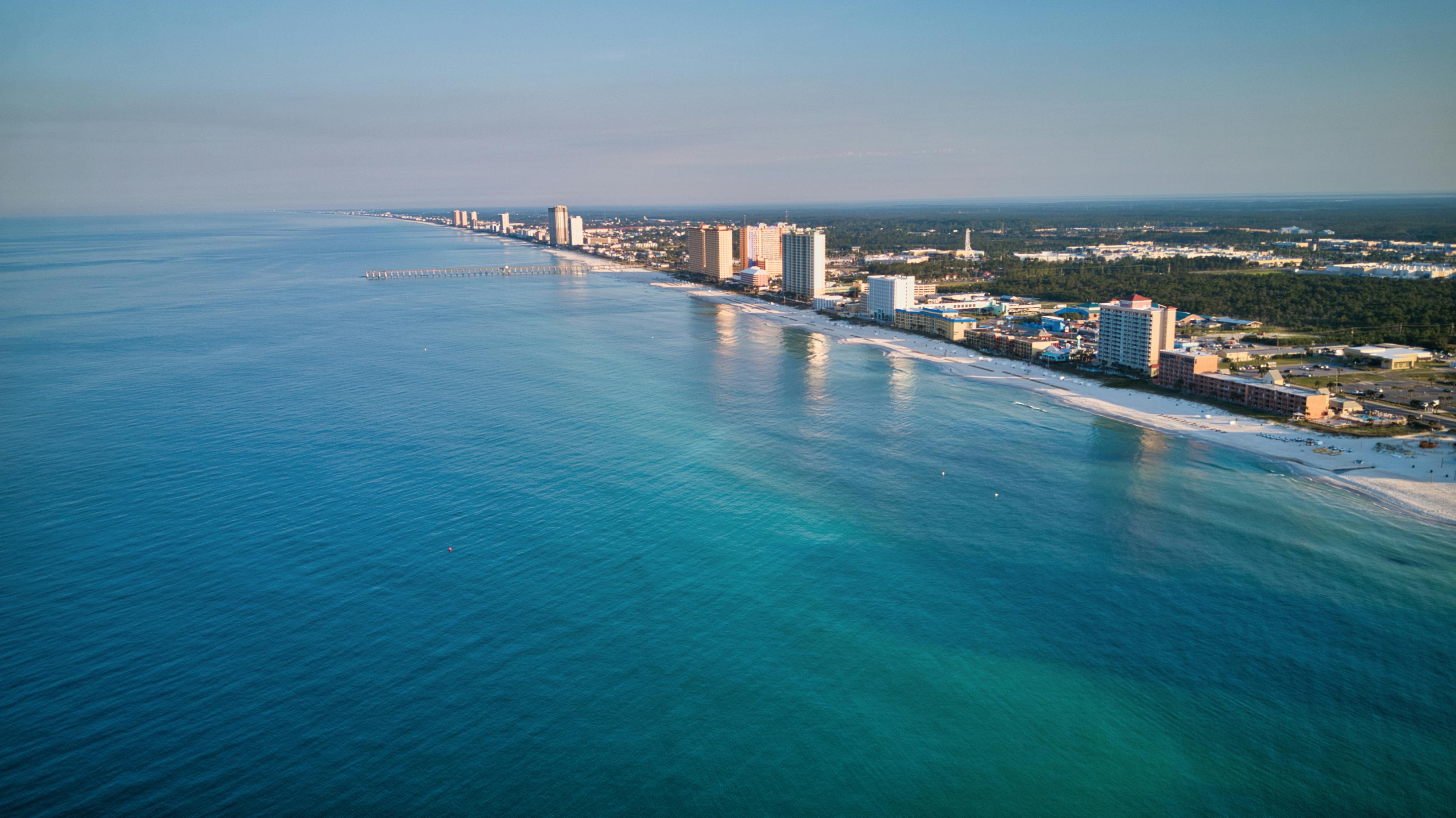 Aerial view of the stunning Panama City Beach coastline, showcasing its pristine waters and vibrant skyline.